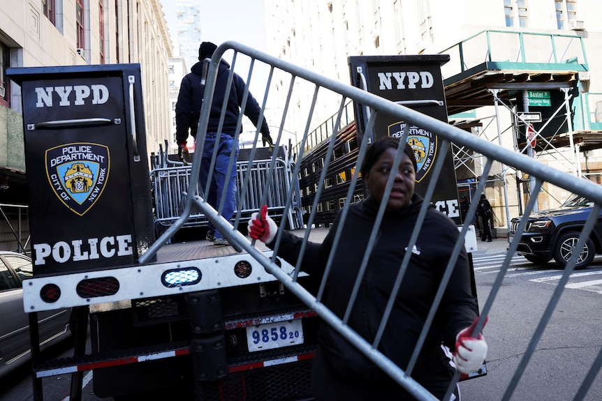 A person holds a barricade outside the Manhattan Criminal Court.