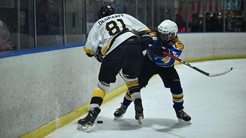 Two ice hockey players clash on the ice