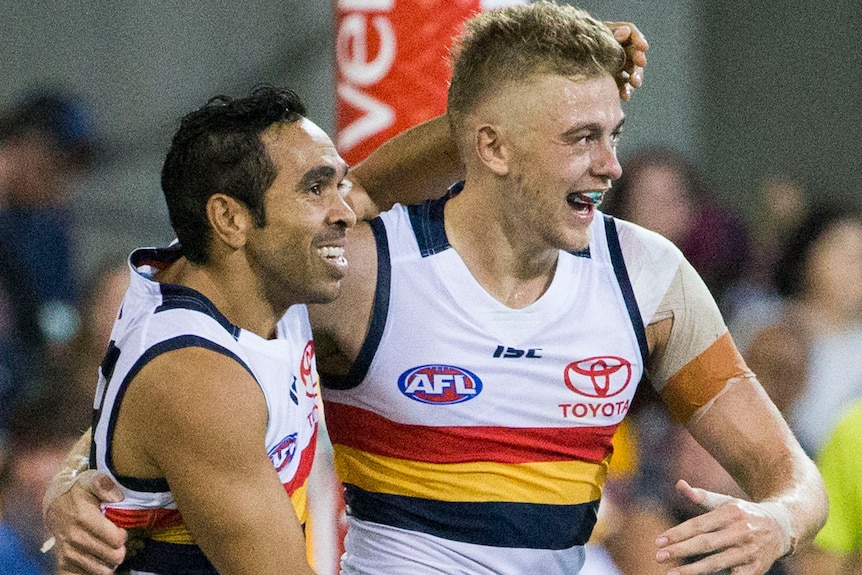 Eddie Betts and Hugh Greenwood share a hug