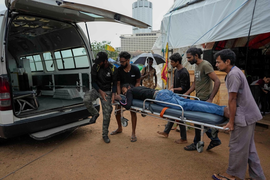 Medics move an injured protester into the back of an ambulance van.