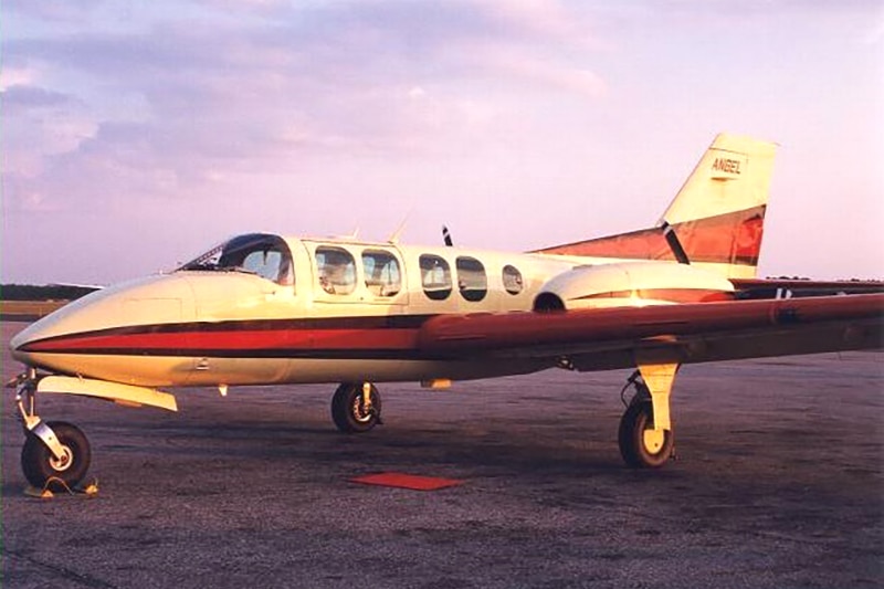 A twin-engine aircraft parked on an airport tarmac