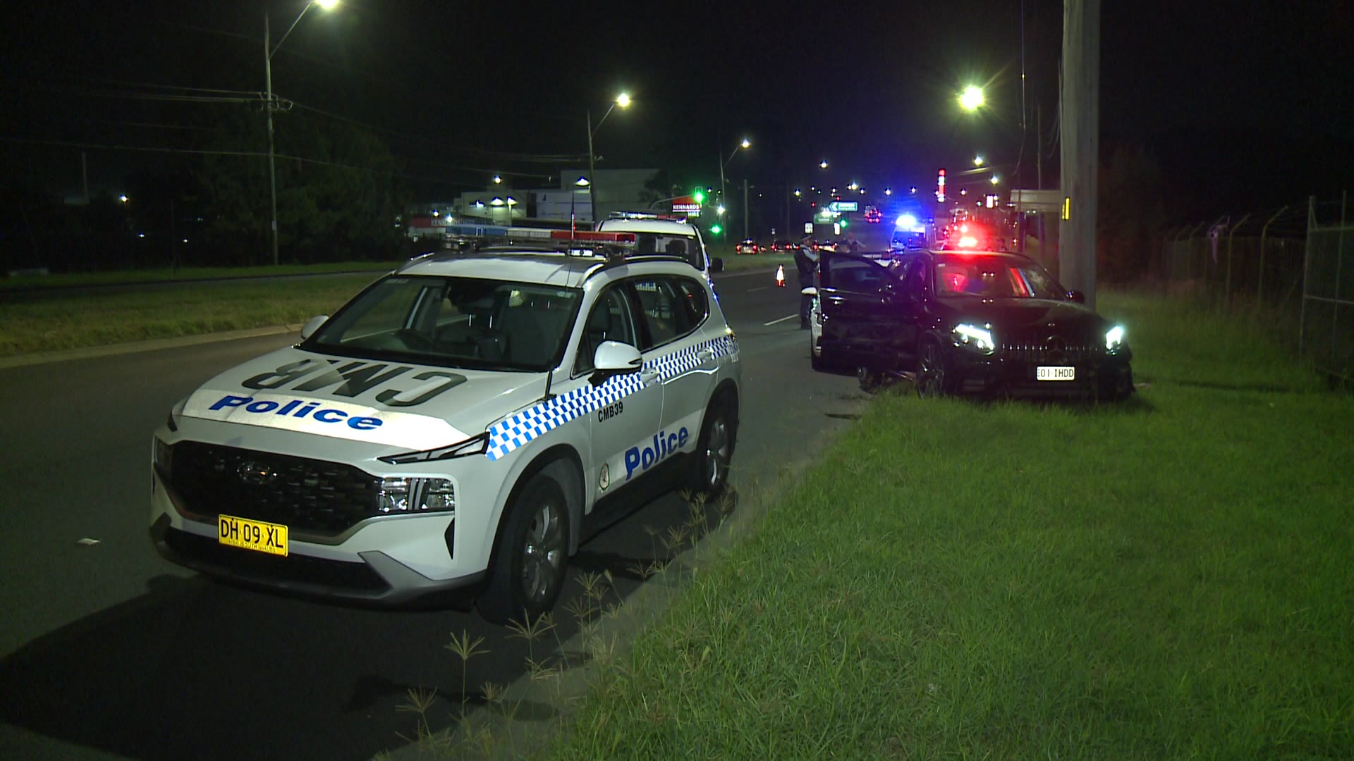 A police car in front of a smashed Mercedes.