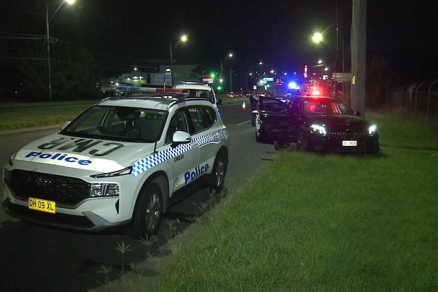 A police car in front of a smashed Mercedes.