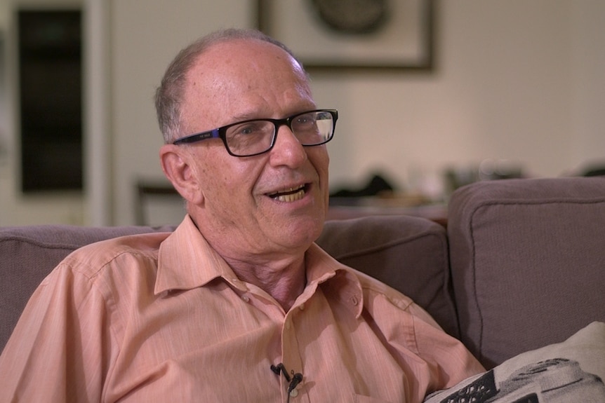 A still from the documentary of Professorial Fellow Dennis Altman seated on a couch.