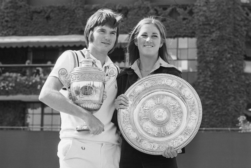 Chris Evert and Jimmy Connors pose for a photo with their trophies.