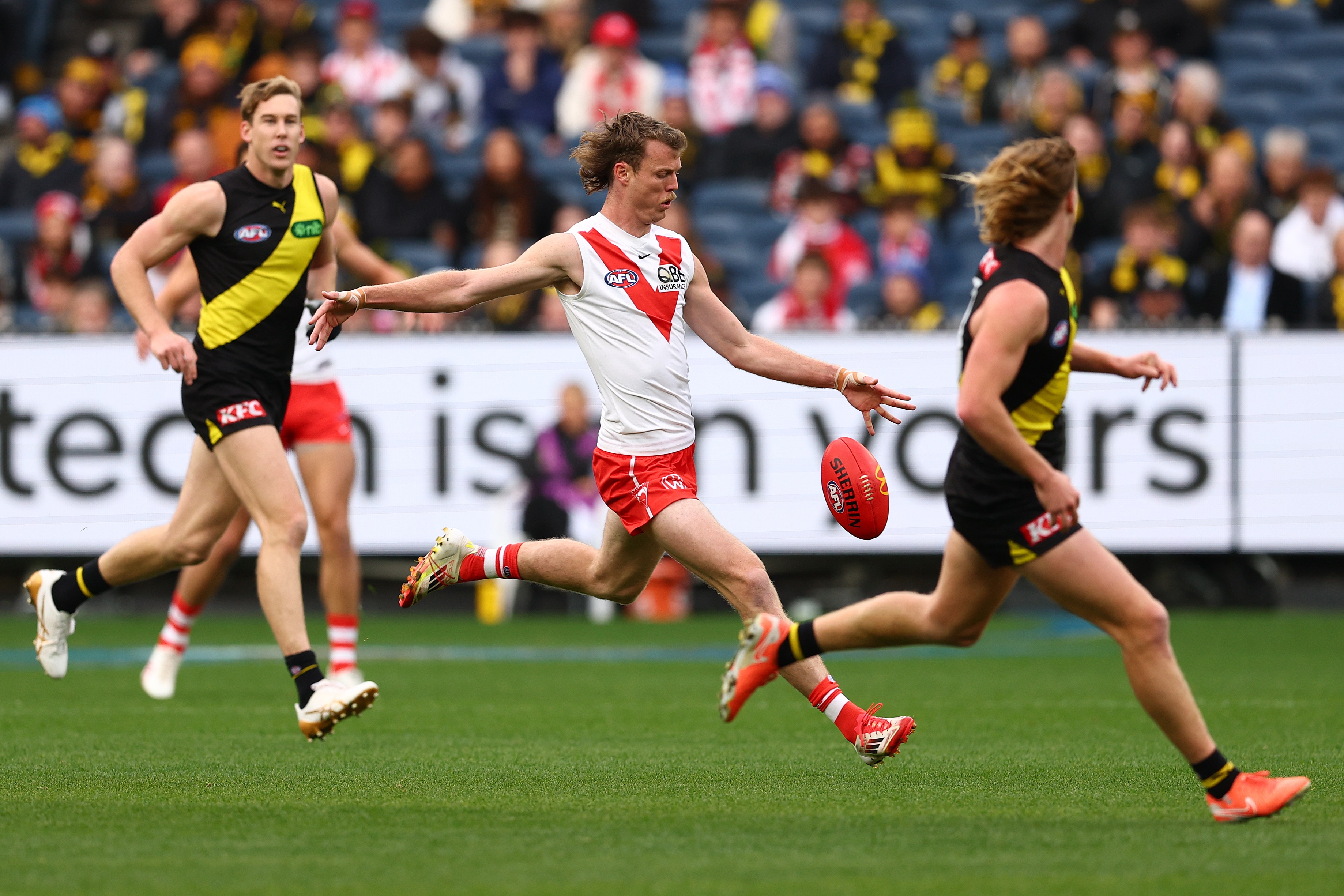 An AFL player prepares to kick the ball