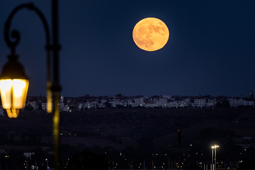 An orange moon lights up the sky in Morocco.