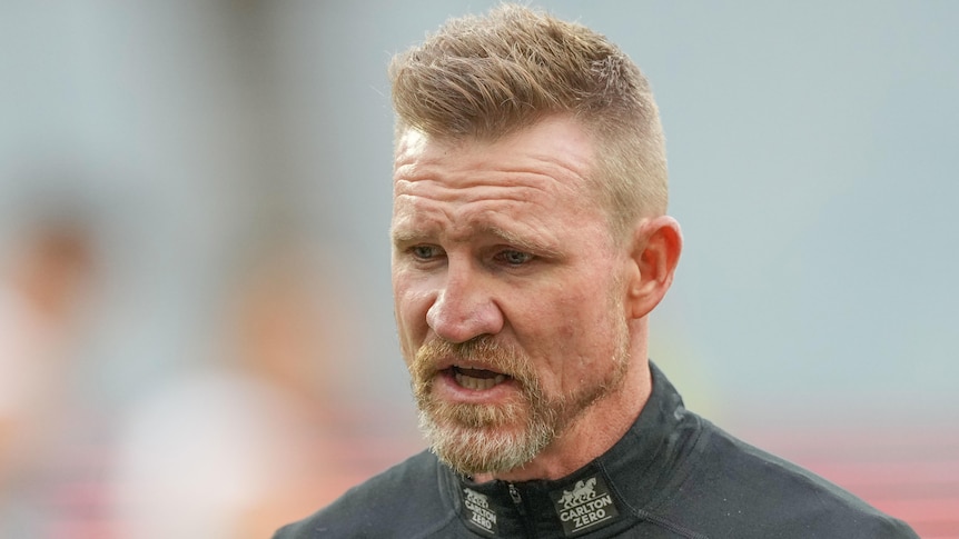 Nathan Buckley walks with a neutral expression on his face