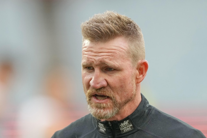 Nathan Buckley walks with a neutral expression on his face