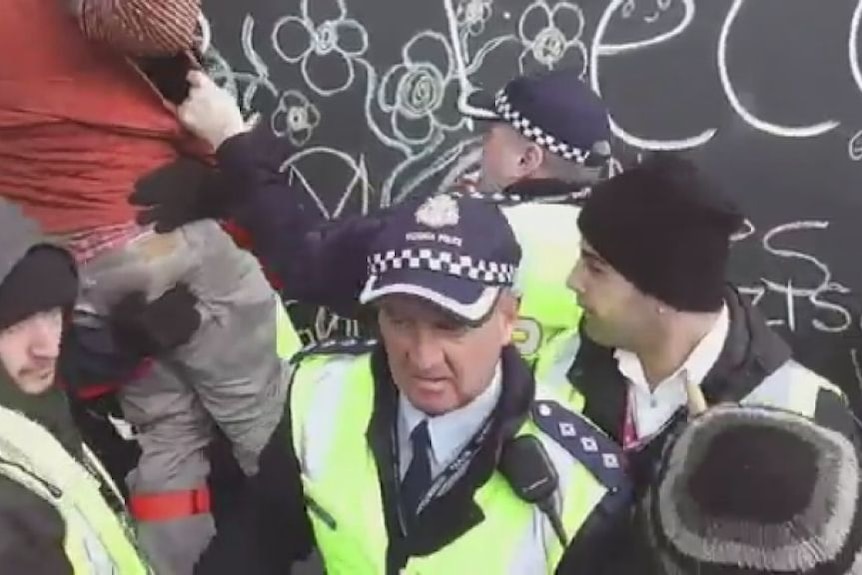 Protesters clash with police as man on stilts ends up on the ground at Tecoma McDonald's site