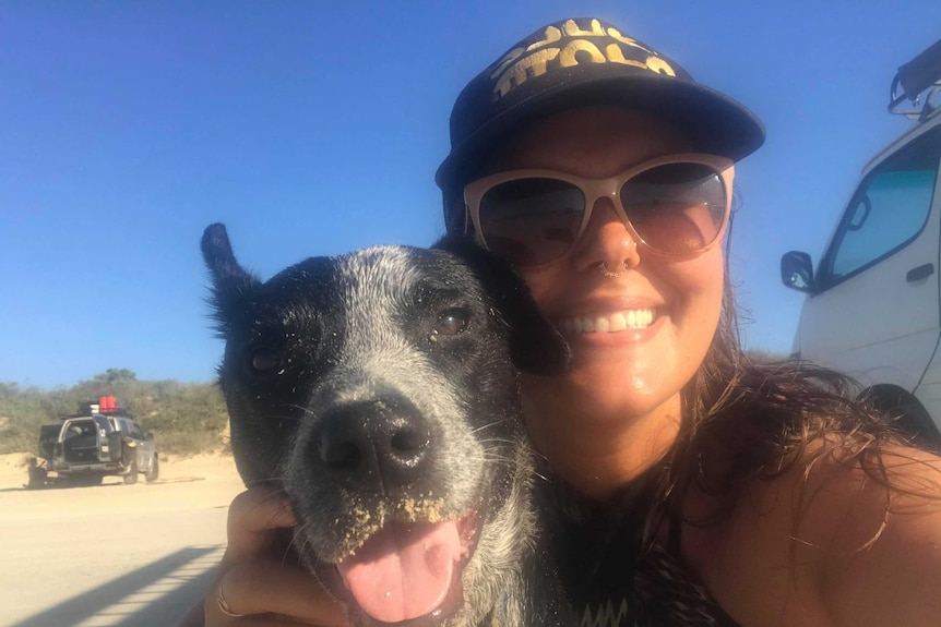 A woman cuddling her dog.