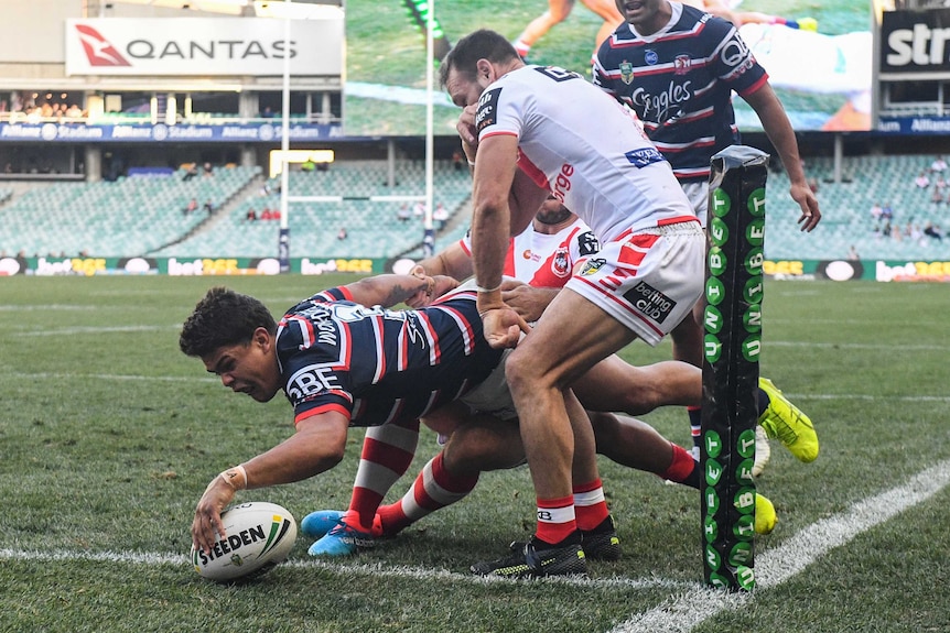 Latrell Mitchell stretches over to score a try for the Roosters in the corner against the Dragons.