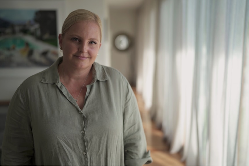 Woman wearing a grey shirt smiling.