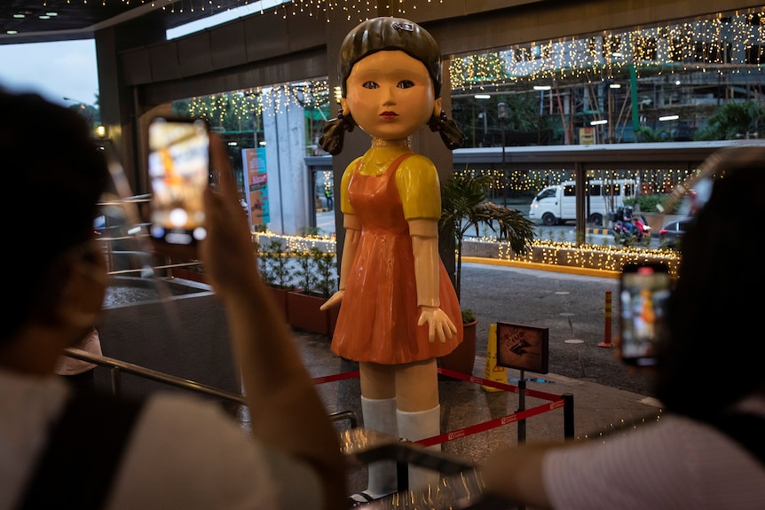 A 3-metre tall doll from the series Squid Game stands in a shopping centre