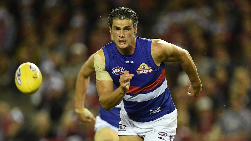 Tom Boyd chasing a yellow football while playing for Western Bulldogs.