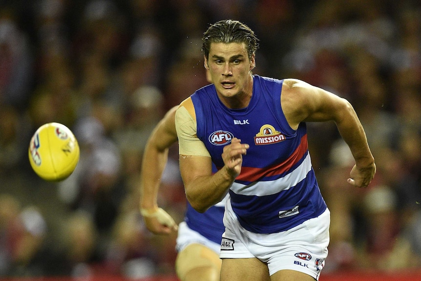 Tom Boyd chasing a yellow football while playing for Western Bulldogs.