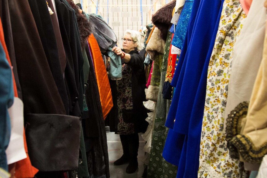 Bronwyn Jones, wardrobe coordinator with Opera Australia standing among the costumes up for auction