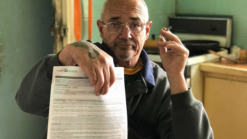 Arthur Johnson smokes a cigarette in his kitchen