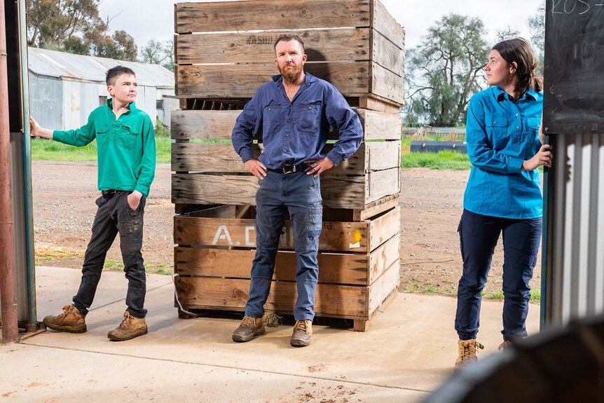 Farmer Chris Stillard at the door to his farm shed with his two children