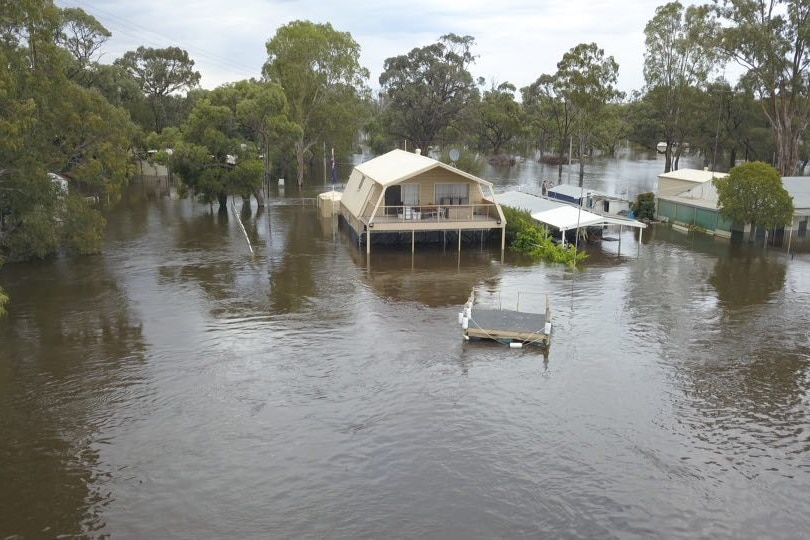 A number of houses are visible rising from flood waters. 