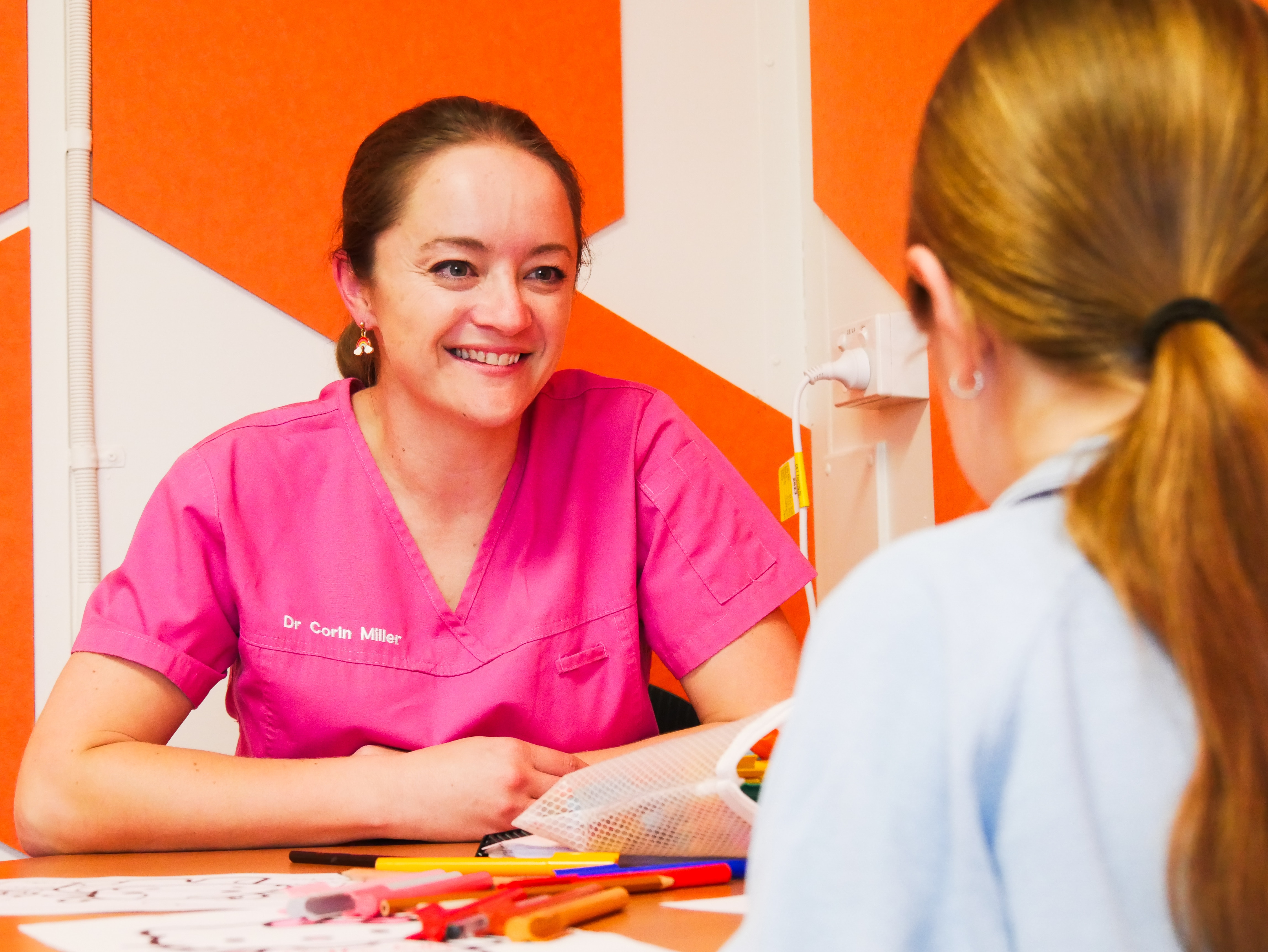 a woman smiling at a child at a table