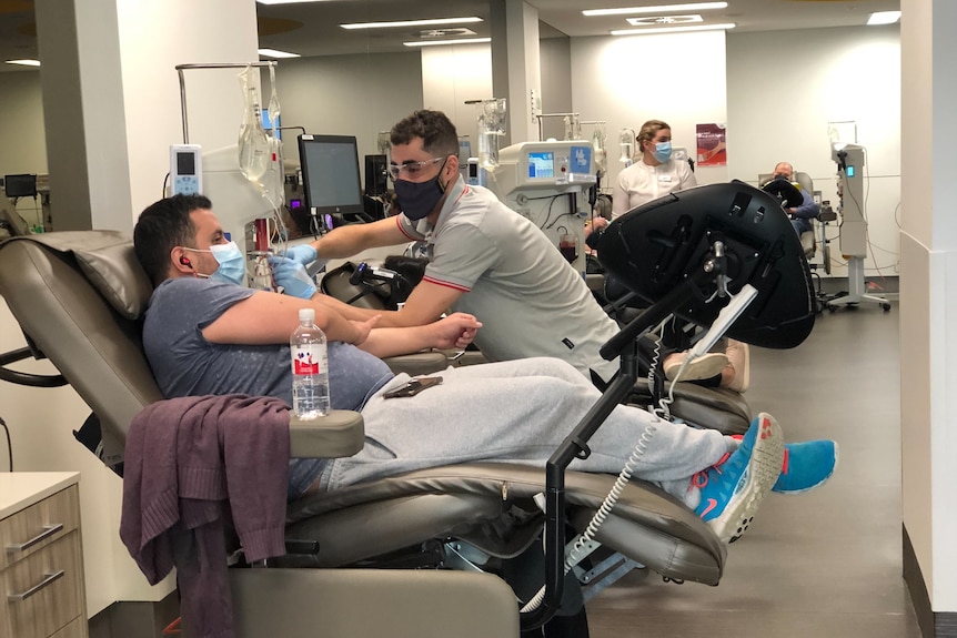 Man lying back at blood donation centre. 