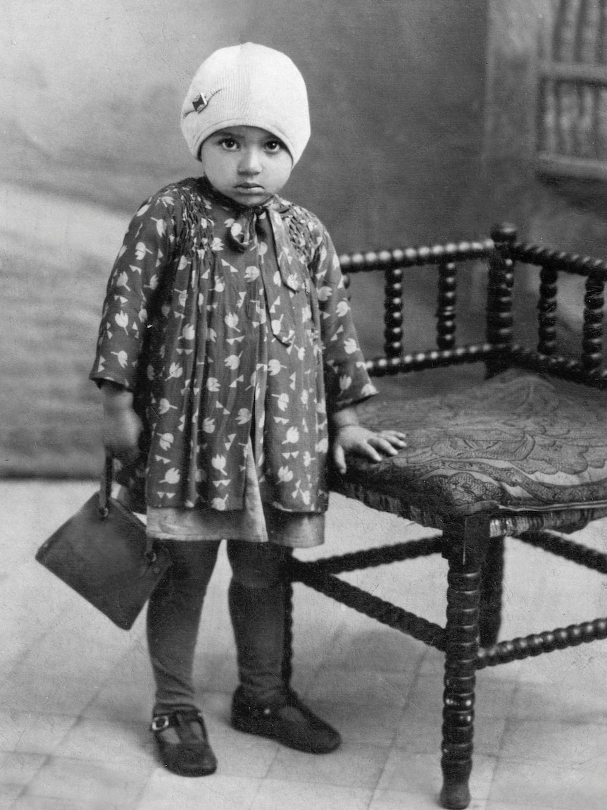 A black and white photograph of the artist Mirka Mora at aged two, wearing a sweet little beanie