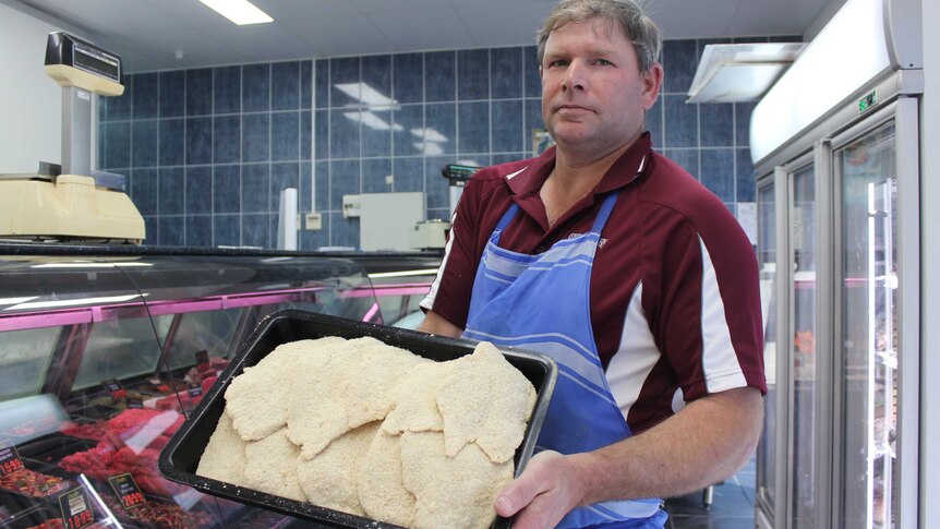 Steve Clauson holds up a tray of chicken schnitzels