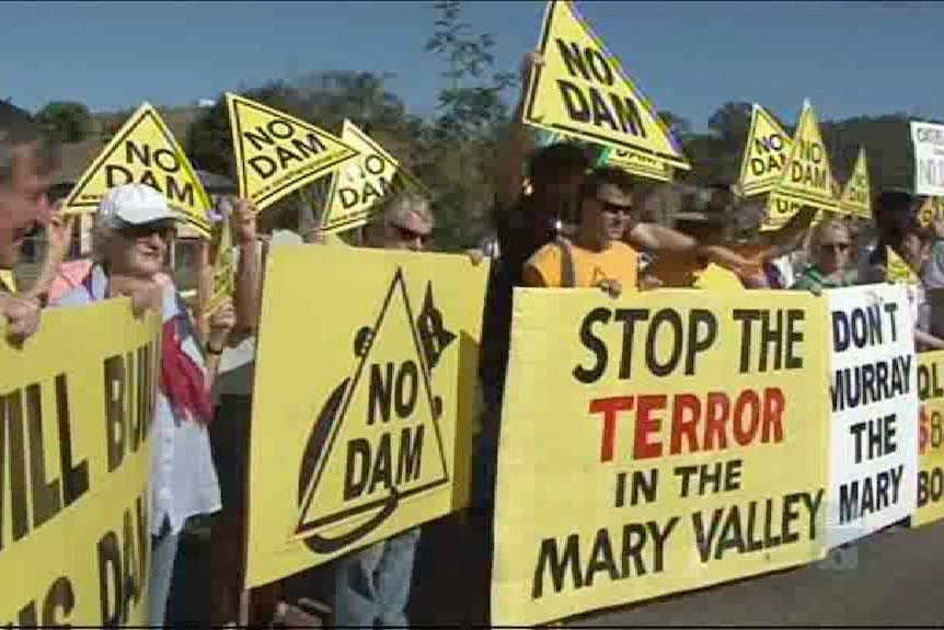 A line of protestors holding up yellow signs.