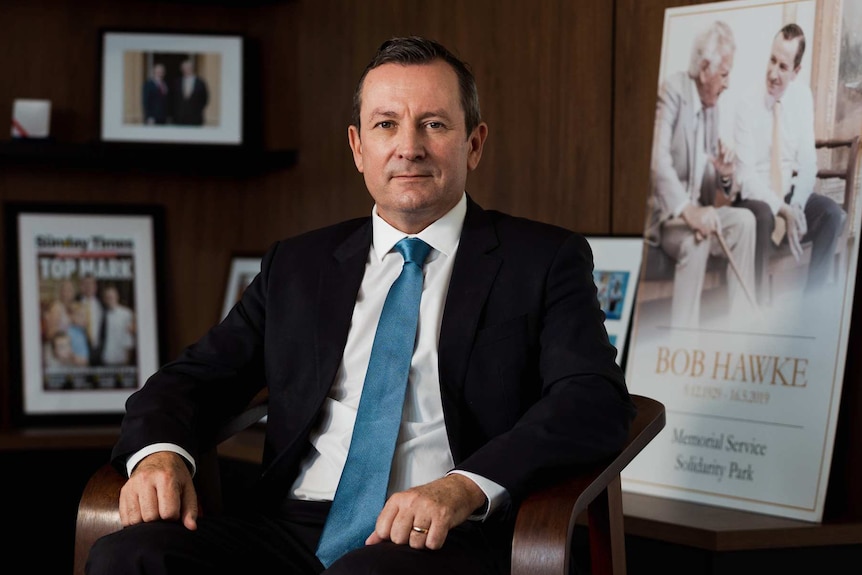 Mark McGowan sitting in an office wearing a suit.