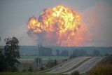 A huge explosion rises on the skyline in the town of Kalynivka.