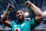 An Irish male rugby union player raises his arms after defeating the All Blacks.