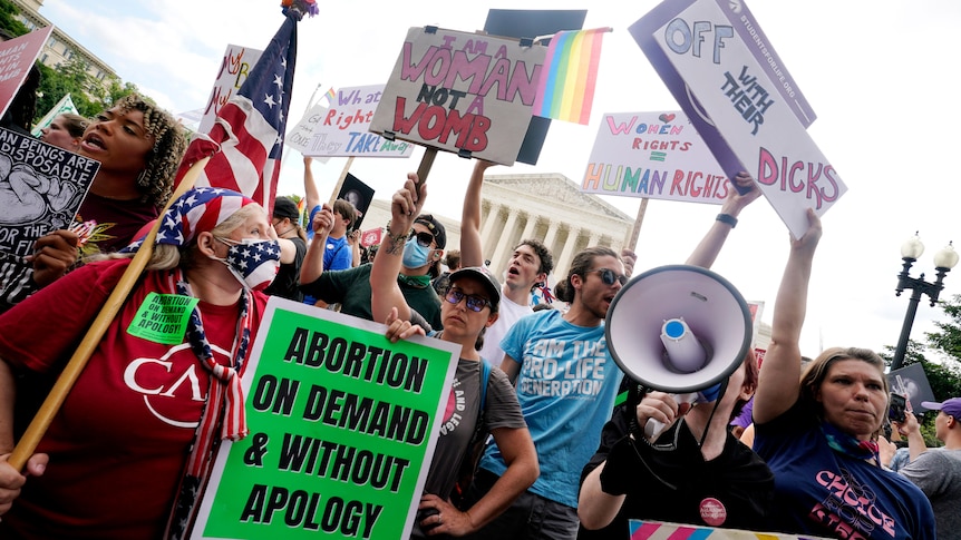 Protesters stand outside Supreme Court building.