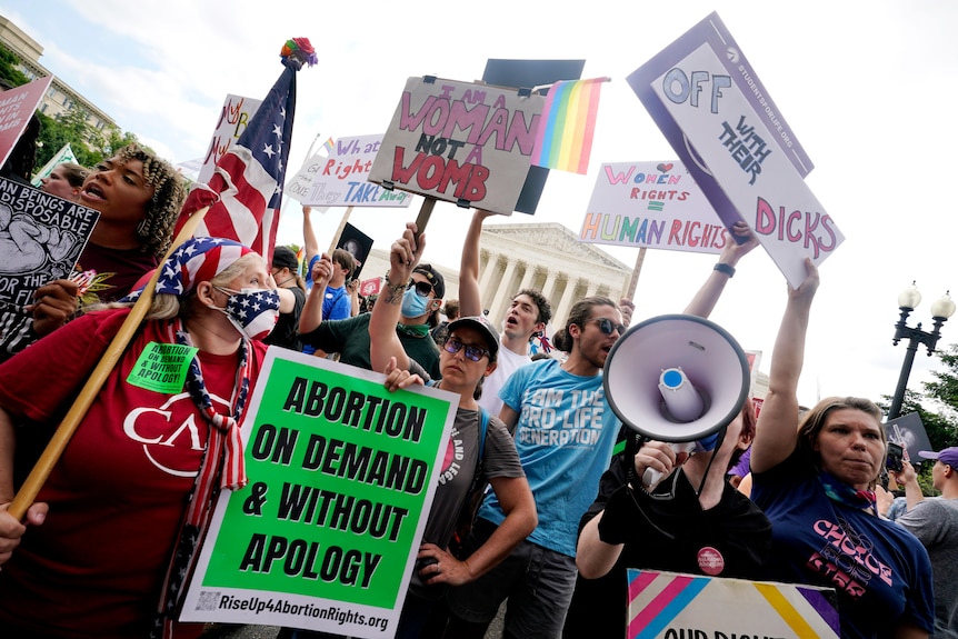 Protesters stand outside Supreme Court building.