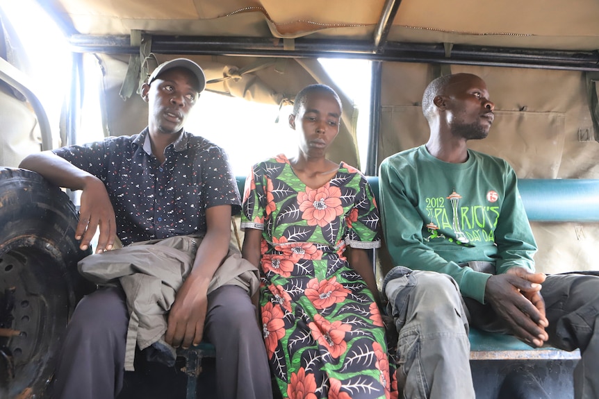 Two men and a woman who are suspected followers of a Christian Cult sit in a car looking down.