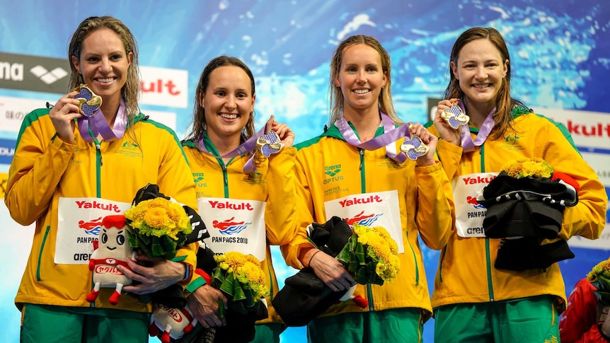 Emily Seebohm, Jessica Hansen, Emma McKeon and Cate Campbell hold up medals.