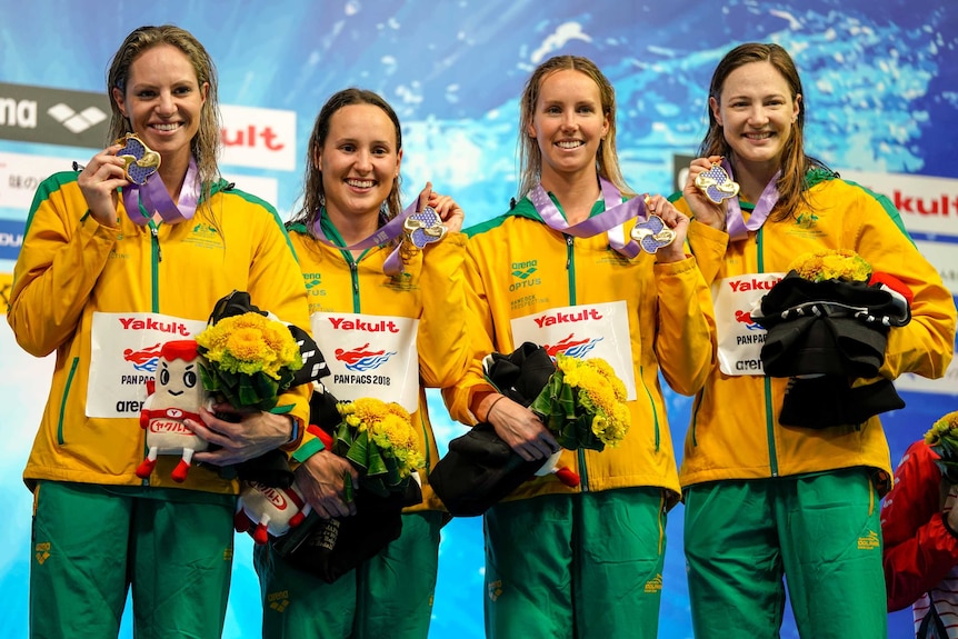 Emily Seebohm, Jessica Hansen, Emma McKeon and Cate Campbell hold up medals.