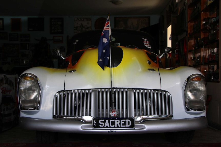 An old car with an Australian coming from its grille