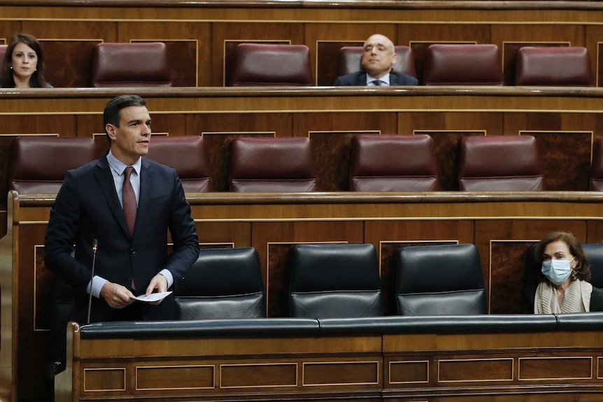 The Prime Minister speaks in a chamber with three other people sitting at a safe social distance.