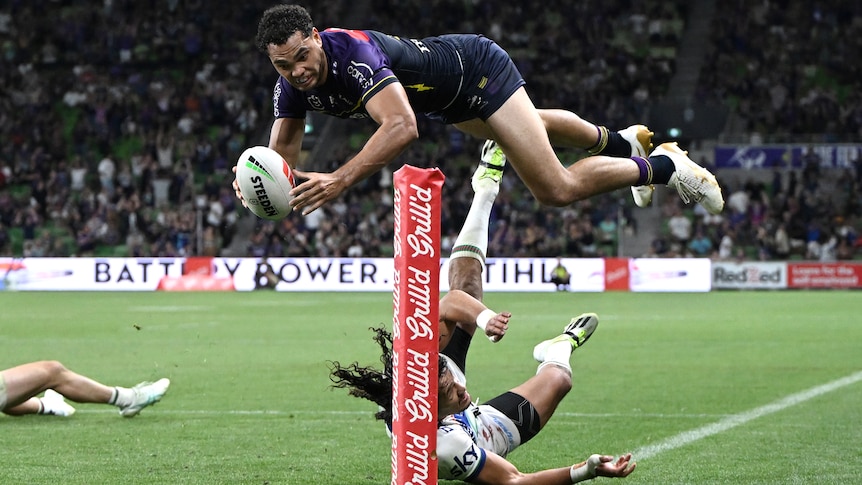 Xavier Coates in the air as he is about to score an NRL try for the Melbourne Storm against the Warriors.