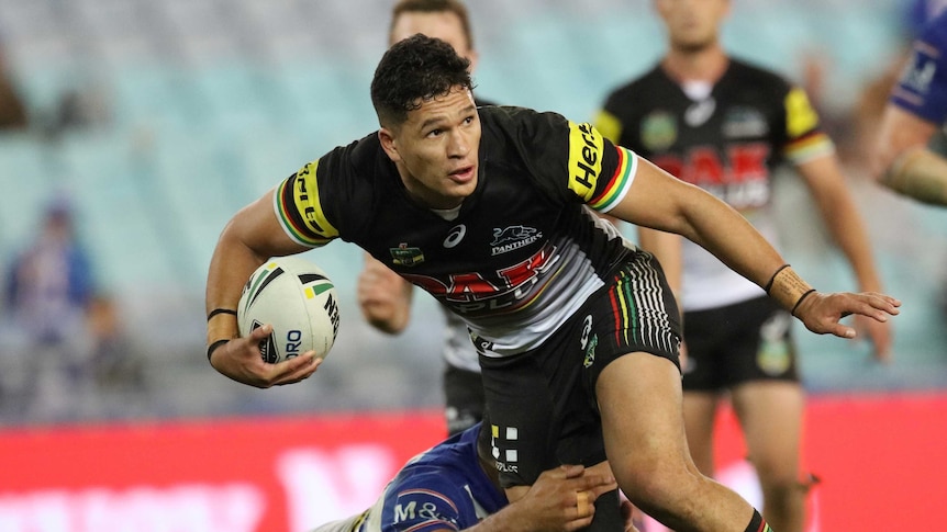 Dallin Watene-Zelezniak of the Penrith Panthers is tackled while playing rugby