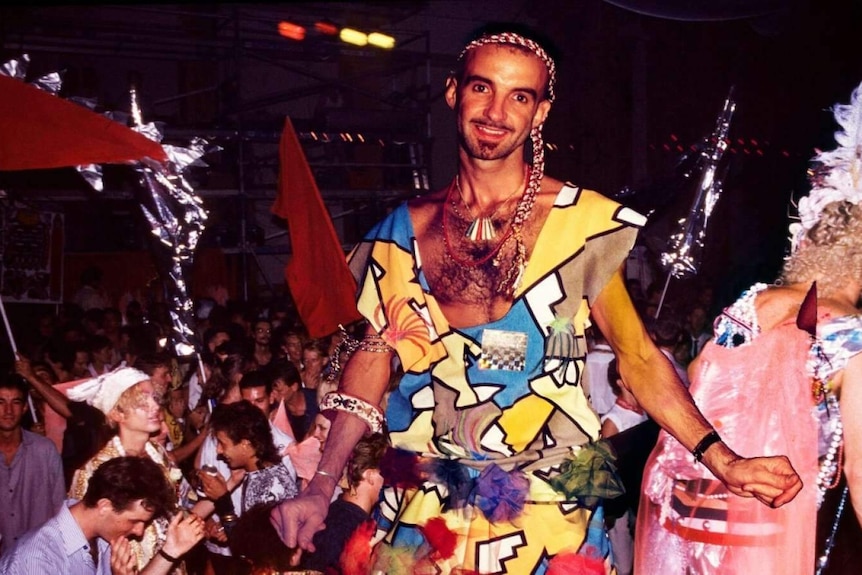 A young man in an outlandish outfit at a party in the 1980s.