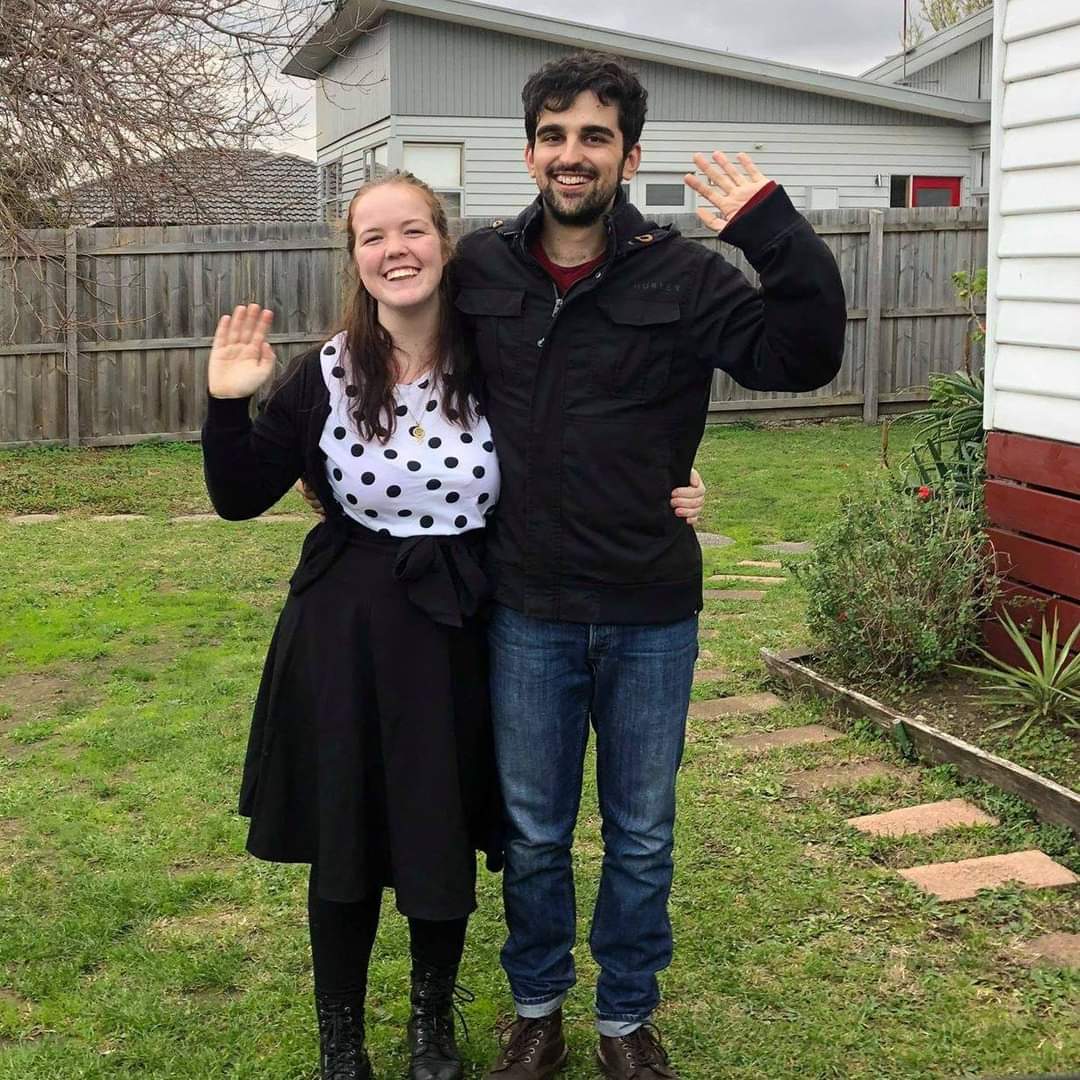 Woman and man waving in a yard, in a story about tips for securing a rental property in a competitive market.