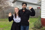 Woman and man waving in a yard, in a story about tips for securing a rental property in a competitive market.