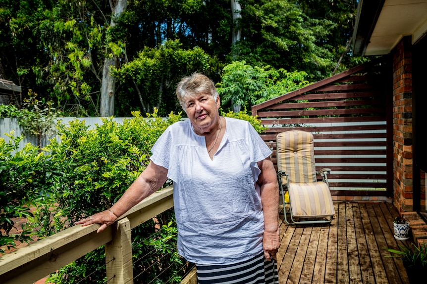 An older woman standing on a balcony