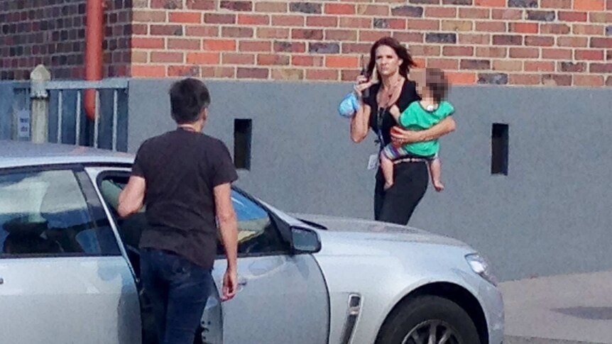 Baby being carried away from siege scene in Geelong