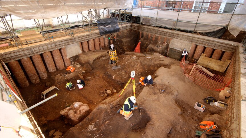 Archaeologists are pictured digging in the grounds of the cathedral. 