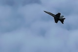 Long shot of a fighter jet flying in the sky
