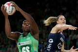 A West Coast Fever player holds the ball above her head against the Melbourne Vixens.