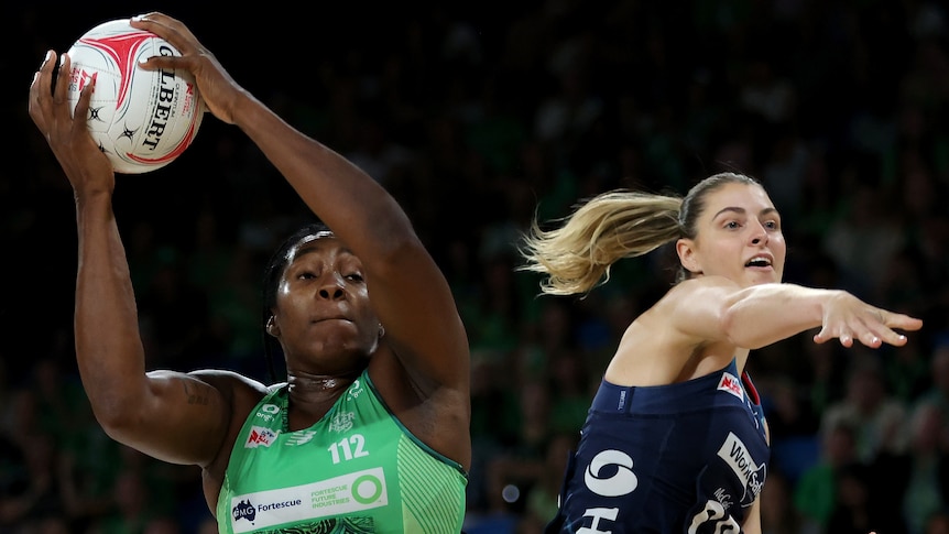 A West Coast Fever player holds the ball above her head against the Melbourne Vixens.